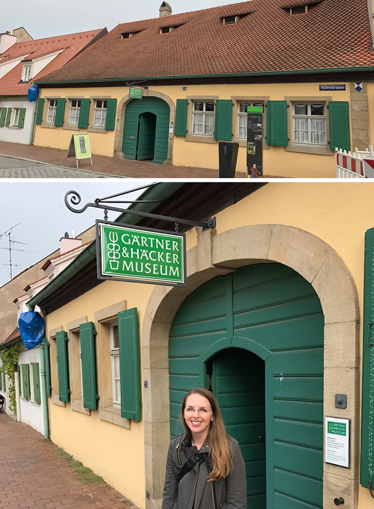 In front of the Bamberg Gardeners' and Vintners' Museum. The through-way, or center large door and foyer of the house was designed to allow a wagon to pass through to store food directly above the living quarters or to the garden out back.