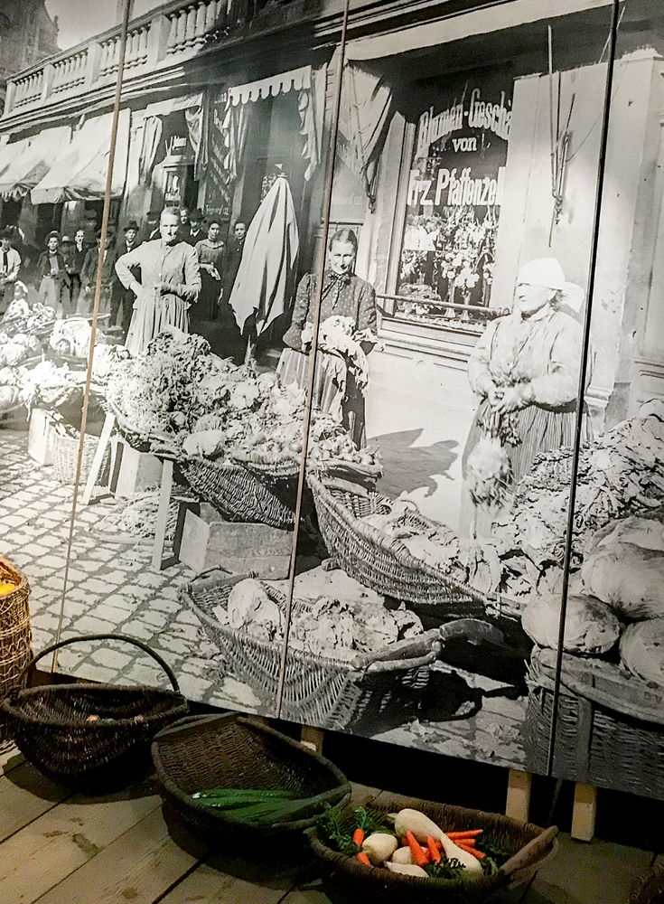 A large black and white graphic to scale of Bamberg market sellers with food baskets in front, an exhibit in the attic of the Bamberg Gardeners' and Vintners' House Museum