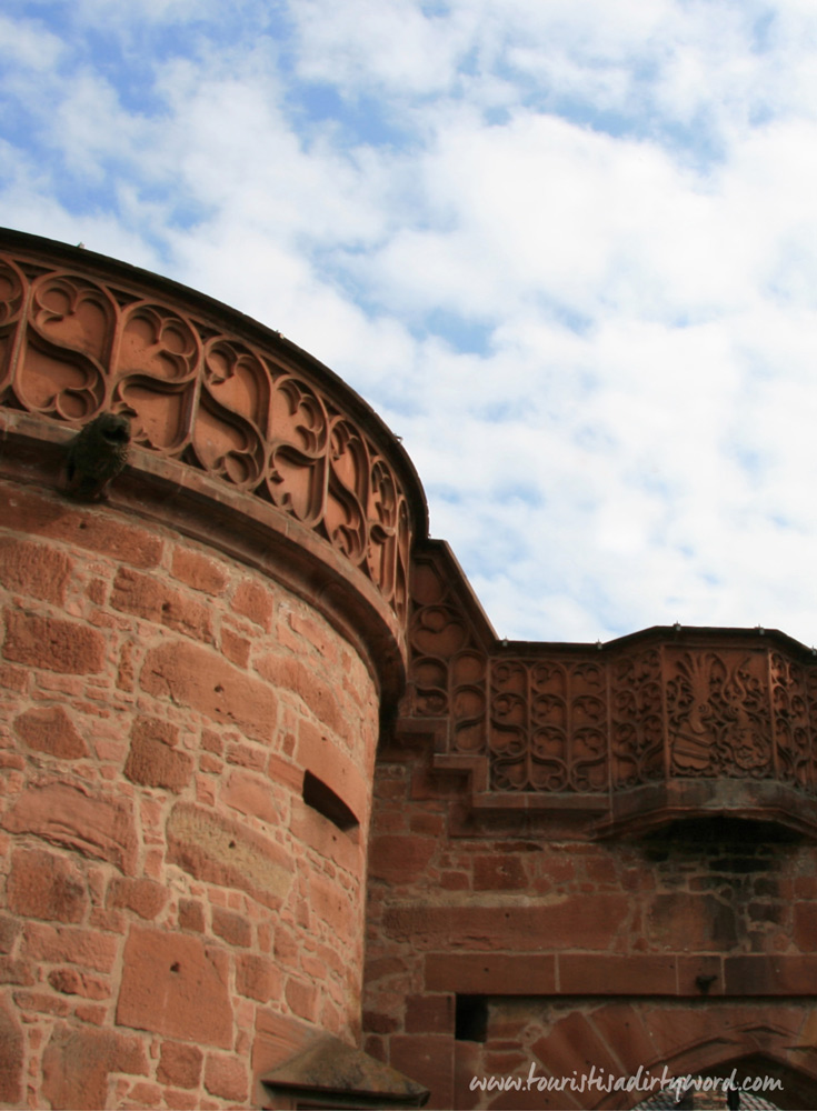 Closeup of the tracery on Buedingen's Jerusalem Gate, showing the lion-head gargoyles and the coat of arms