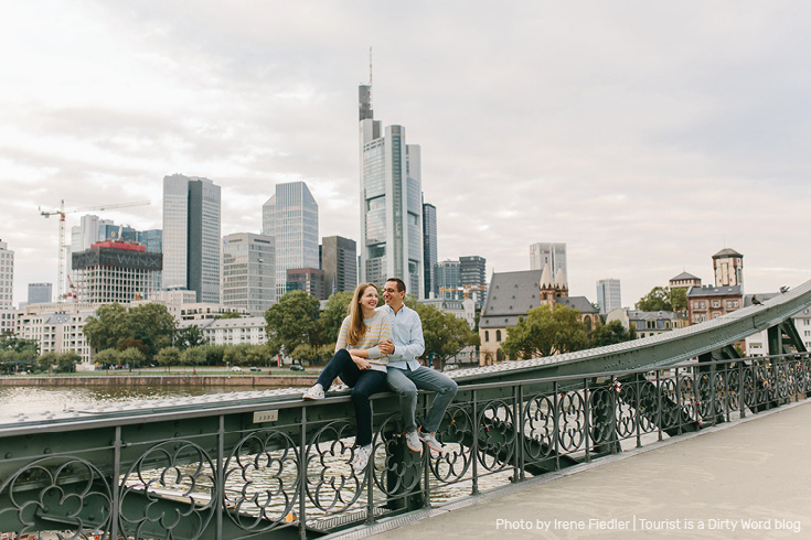 Posing on the Eiserner Steg bridge in front of the 'Mainhattan' skyline of Frankfurt am Main | Photo by Irene Fiedler for Tourist is a Dirty Word Blog