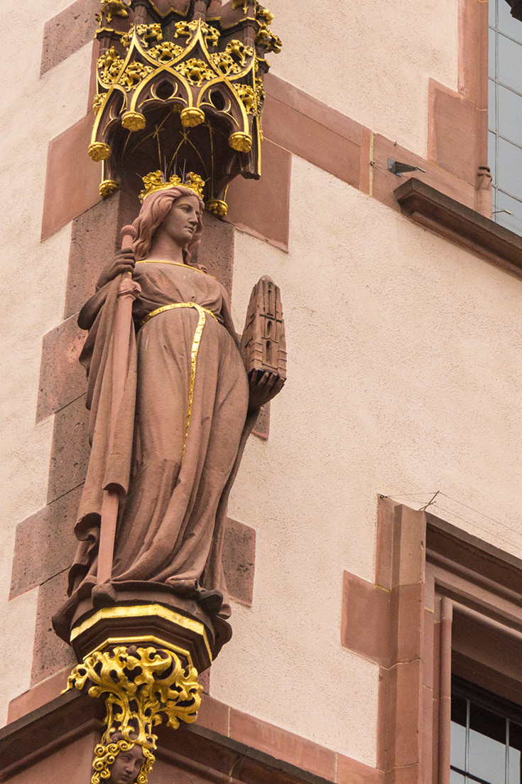 On the neighboring building front to the left of the Roemer, the Alt-Limburg house, be sure to see the ‘Frankfurtia’, Statue, or as Germans know her, Francofurtia, the female embodiment, protector of the city of Frankfurt. She's holding the sword of Charlemagne in her right hand and the Pfarrturm, church tower in her left.