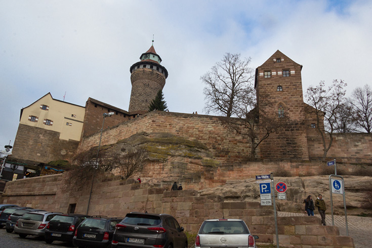The Imperial Castle of Nuremberg sitting on its hill with the odd juxtaposition of a modern parking lot in front of a medieval castle