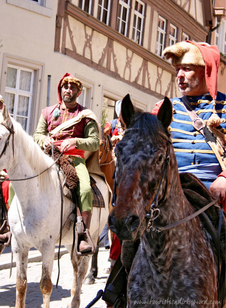 Historically costumed riders parade through the streets of Rothenburg during The Master Draught festival 
