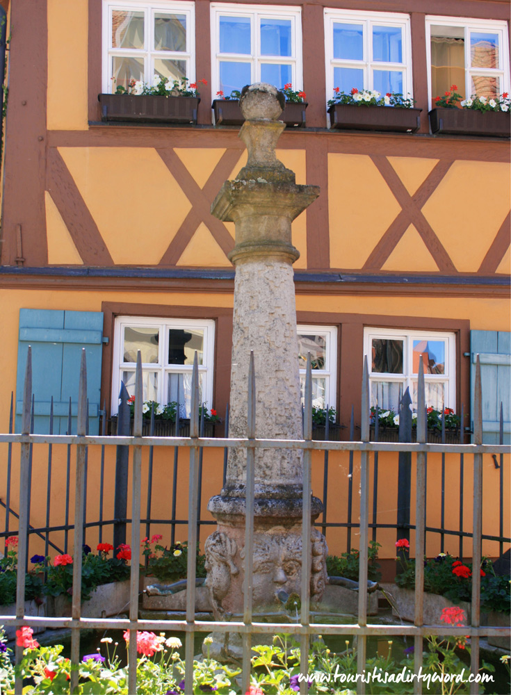 Little garden and statue in front of a half-timbered house in Rothenburg ob der Tauber